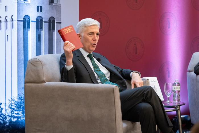 US Supreme Court Justice Neil Gorsuch holds up a copy of Herbert Hoover’s The Challenge to Liberty while speaking at the Hoover Institution’s Winter Board of Overseers meeting on February 24, 2025. 