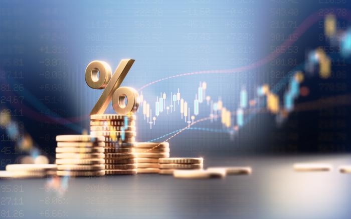Percentage Sign On Top Of Coin Stacks Before Blue Financial Graph stock photo