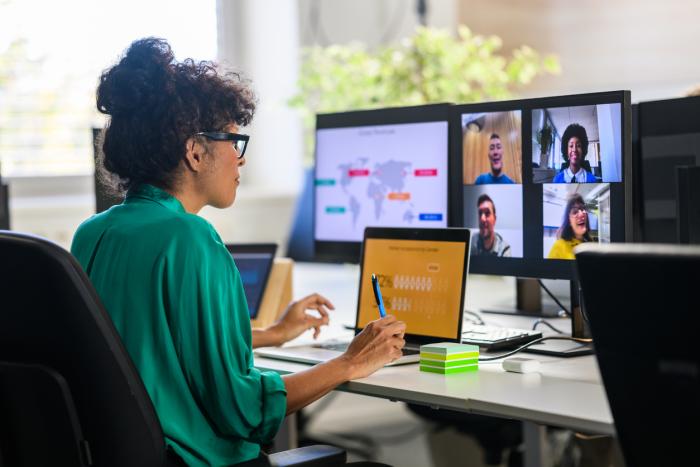 Woman discussing report with remote workers stock photo