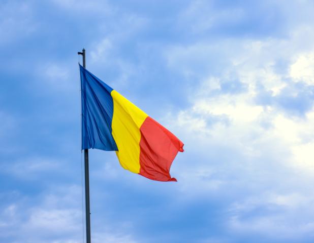 Romanian national flag against romantic sky in Bucharest, Romania - stock photo