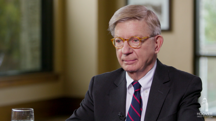 Image of George F. Will sitting at a table.