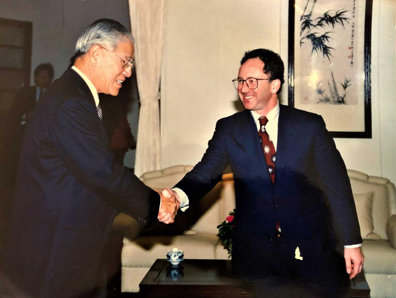 Two men wearing suits shaking hands