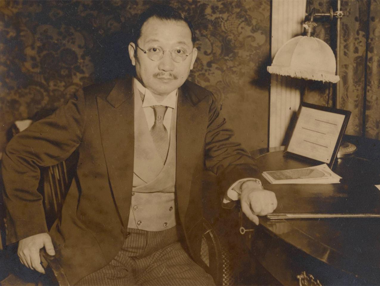 Sepia tone photograph of H. H. Kung seated at desk, 1930s