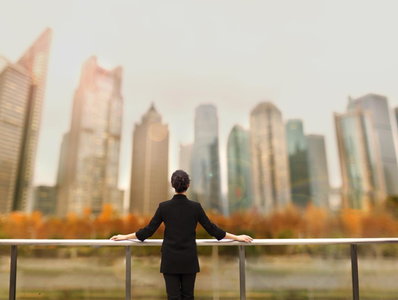 Young woman standing with view of buildings in city downtown
