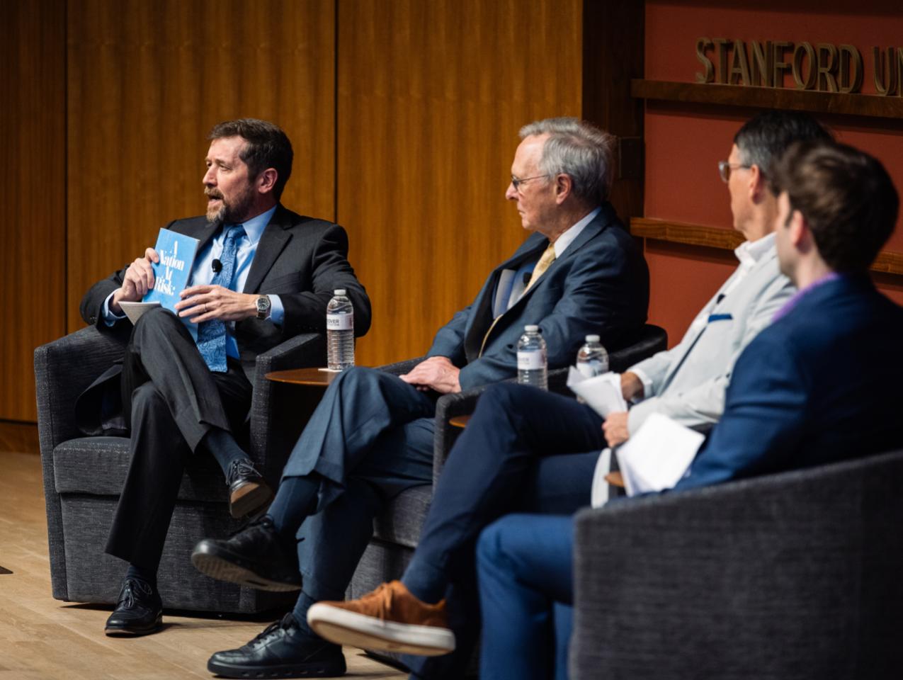 Hoover Education Success Initiative Director Stephen Bowen (left) holds a copy of the original 1983 A Nation at Risk report on US public education during a panel discussing the history of public education reform on January 10, 2025. (Patrick Beaudouin)
