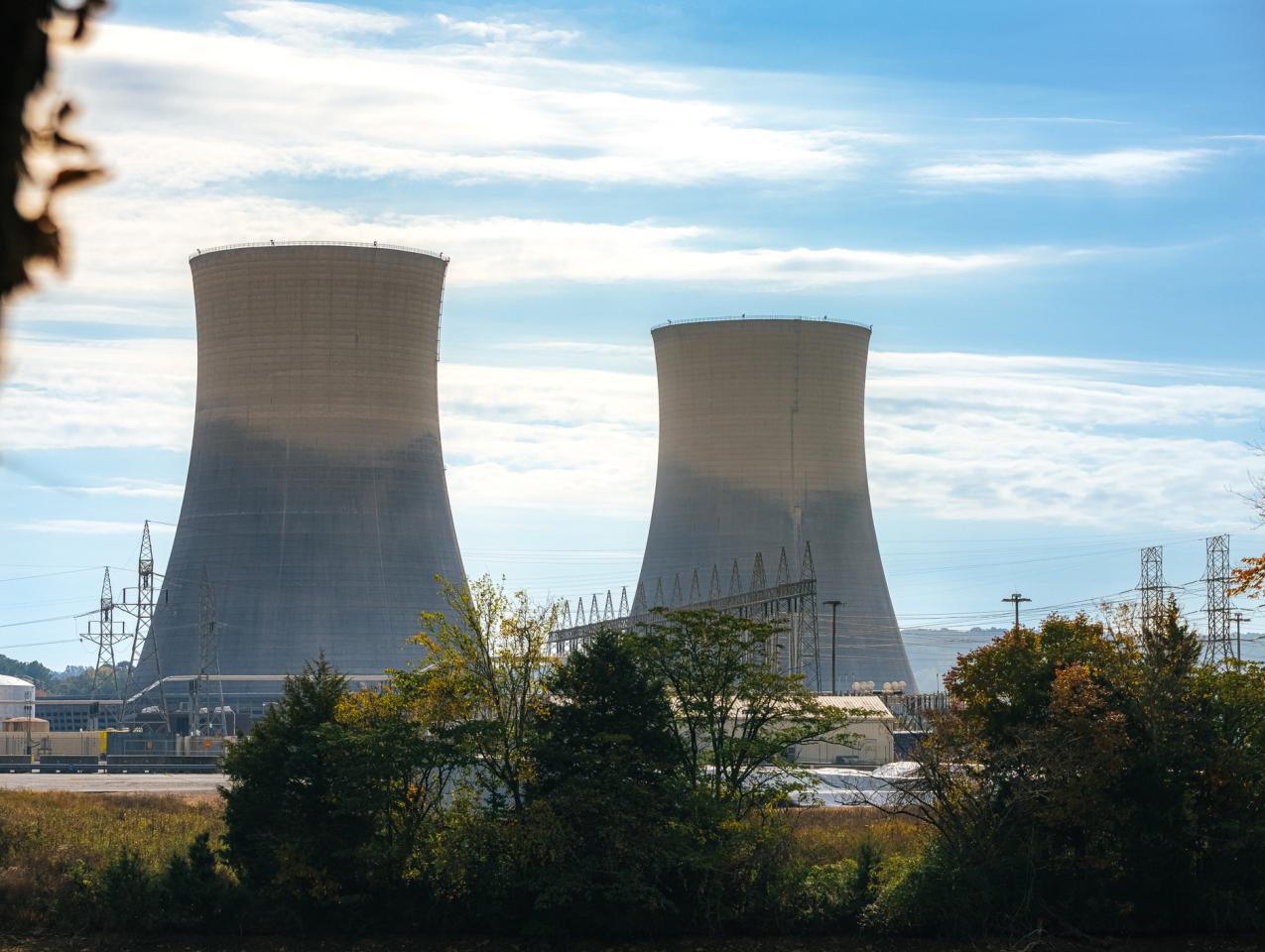 Green Trees surrounding the tall Cooling Towers of a Nuclear Power Plant in Tennessee on a Sunny Autumn Day stock photo
