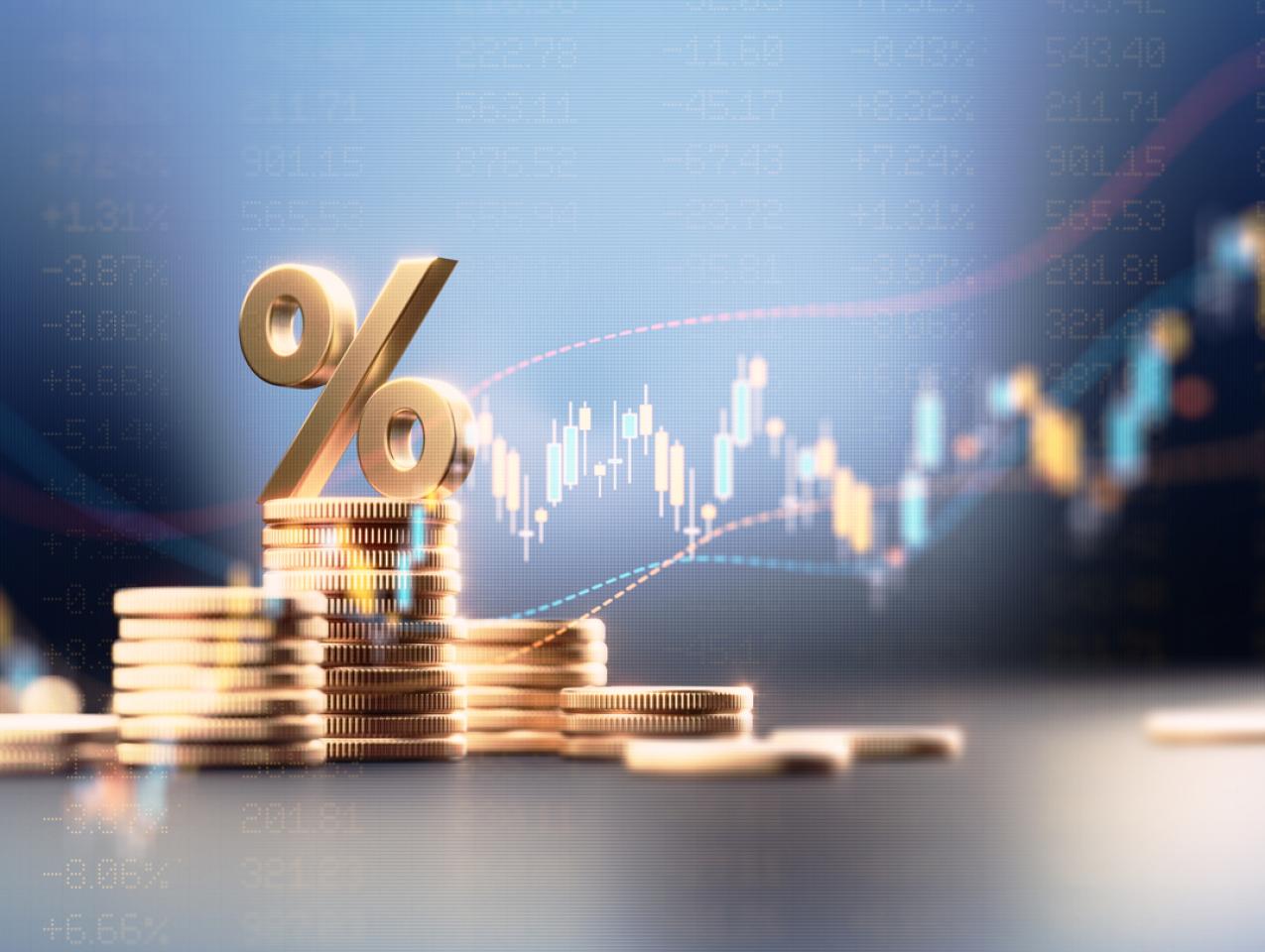 Percentage Sign On Top Of Coin Stacks Before Blue Financial Graph stock photo