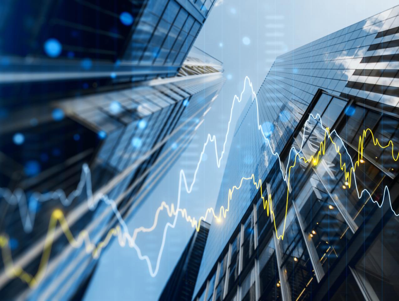 A double exposure image of skyscrapers with overlay of financial graphs, set against a blurred background, illustrating the concept of business growth stock photo
