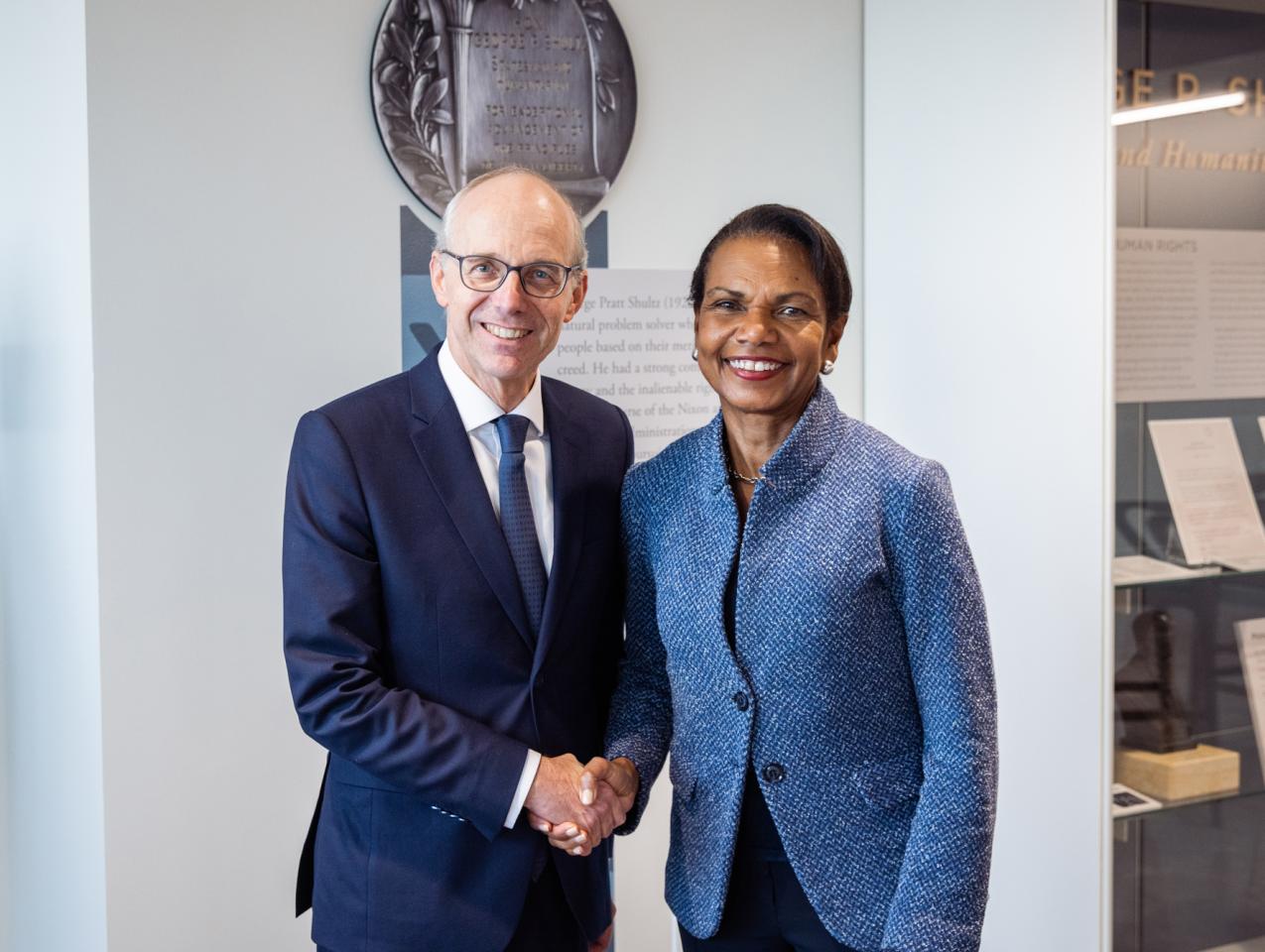 Luxembourg Prime Minister Luc Frieden and Hoover Institution Director Condoleezza Rice shake hands in Hoover’s George P. Shultz Building on November 11, 2025. (Patrick Beaudouin) 