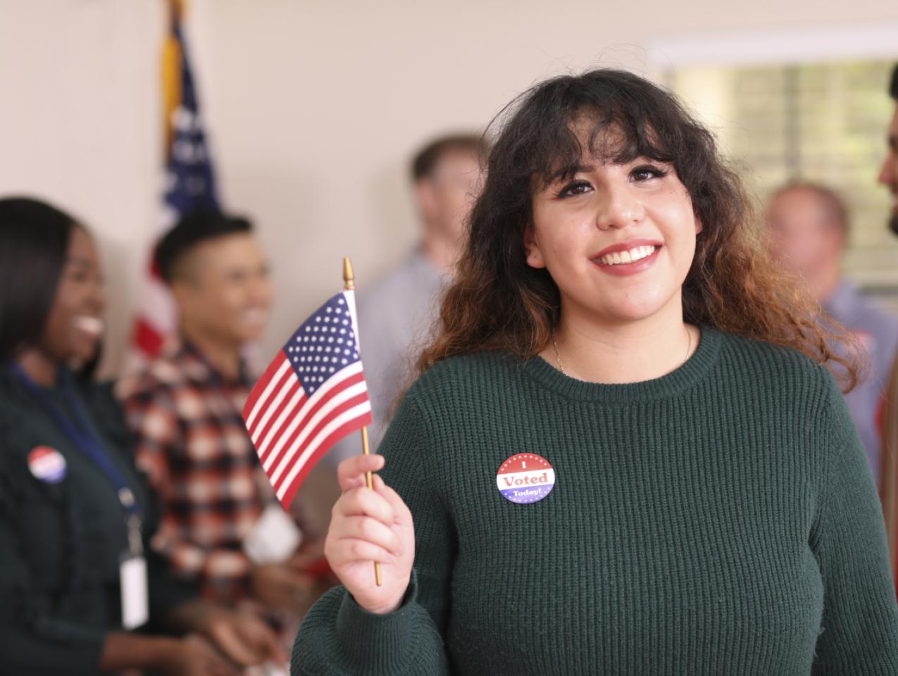 Young adult, Latin descent woman votes in USA election. - stock photo
