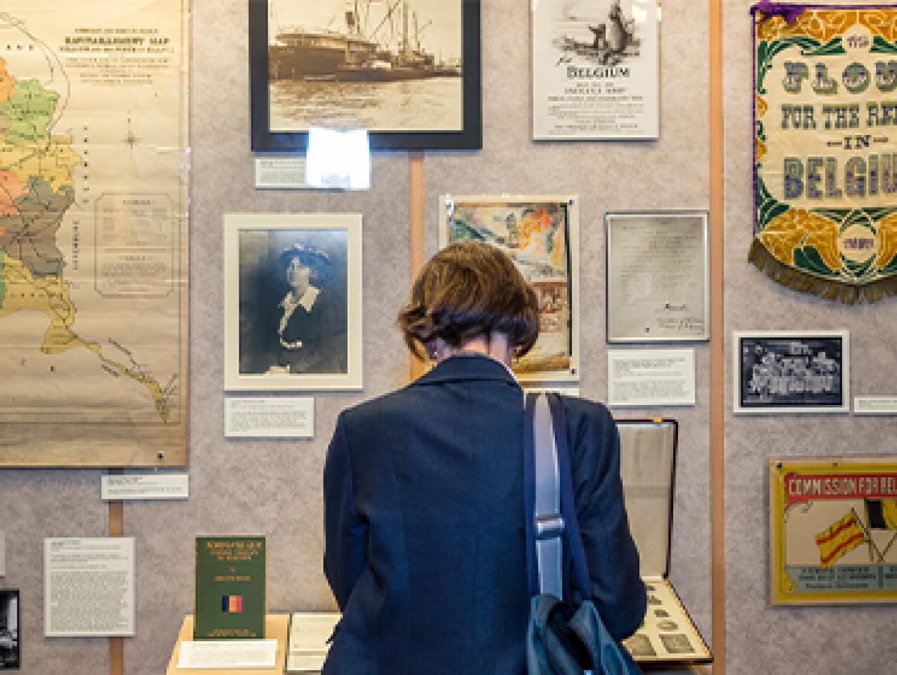 Color photograph of a woman standing in front of a past exhibition display at Hoover