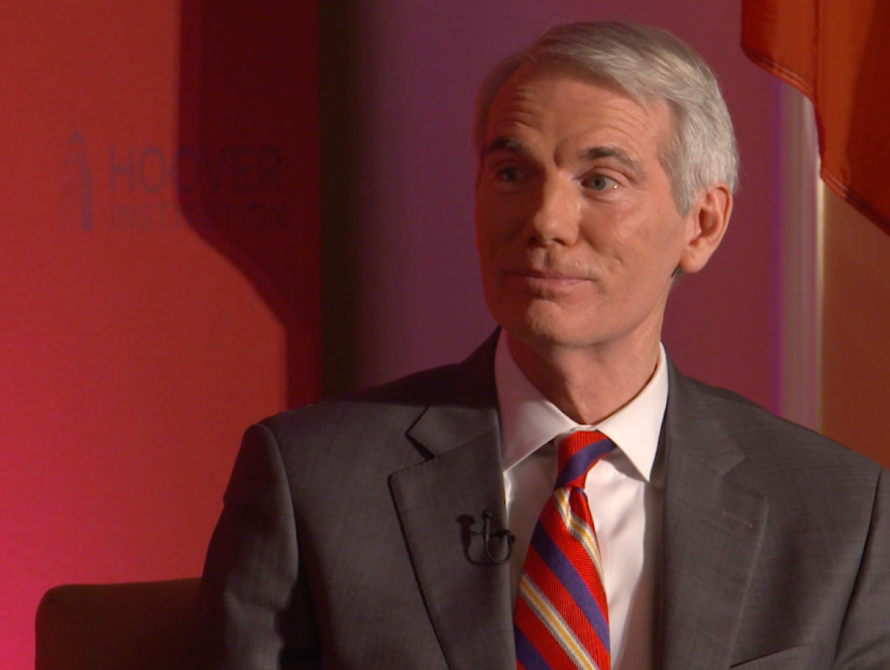 Image of Senator Rob Portman in front an orange-red background