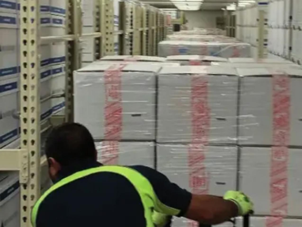 Photograph of boxed archival materials being moved