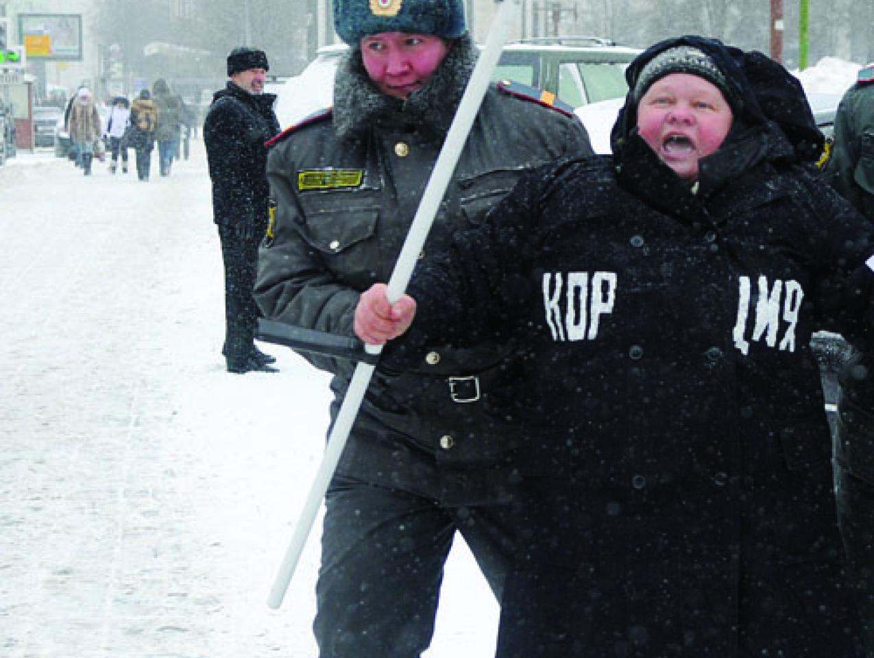 Moscow police officer detains a demonstrator