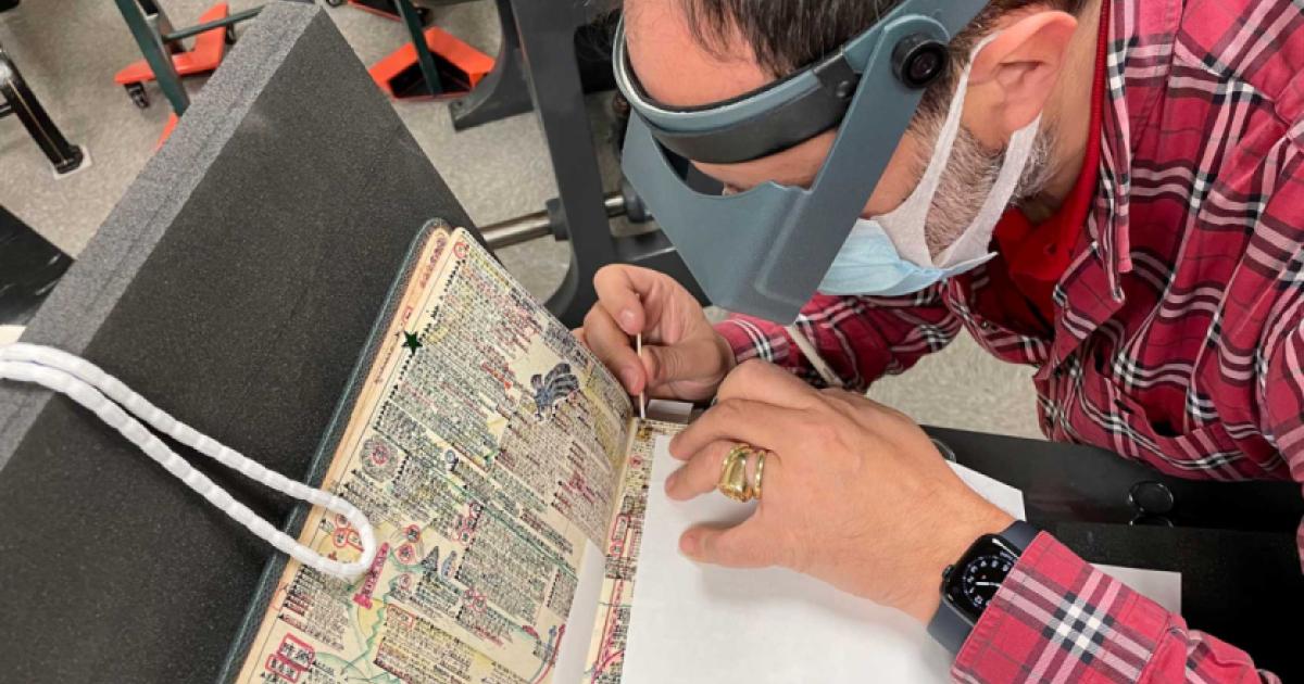 Laurent Cruveillier wearing magnifying goggle during conservation treatment of the Kitaji Bibles