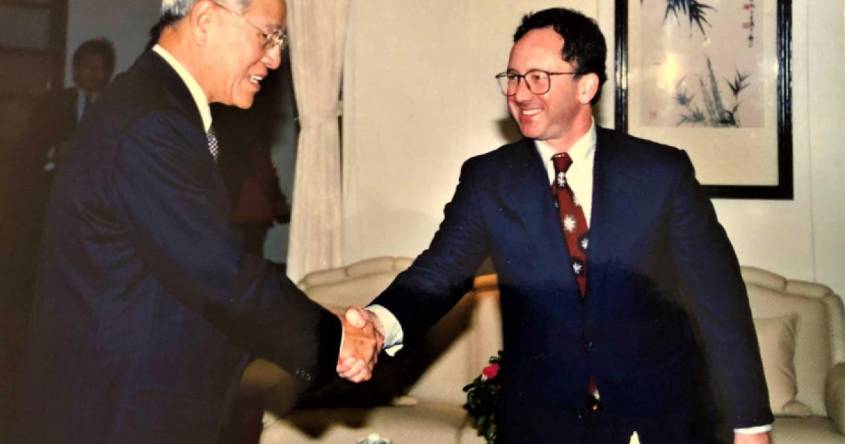 Two men wearing suits shaking hands