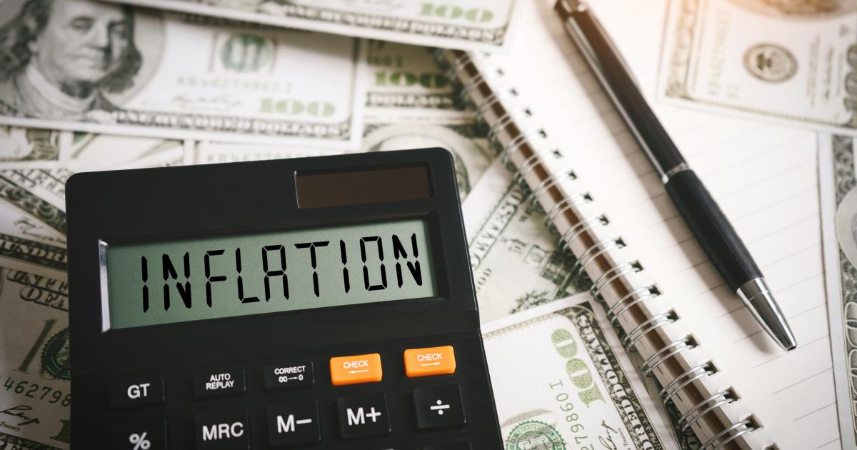 Calculator stating inflation with money in the background