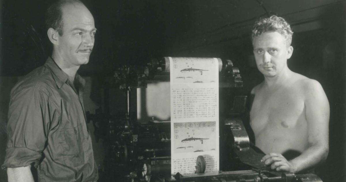 Two men operating a print press at the Office of War Information