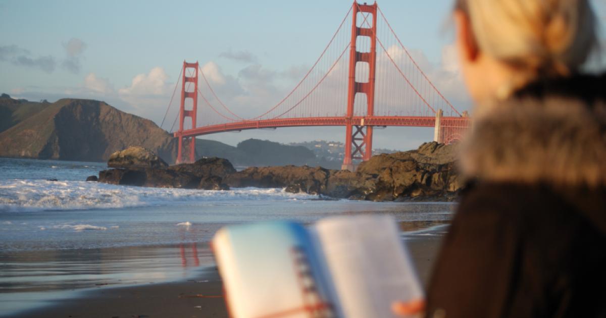 Californian reading a book near the Golden Gate Bridge