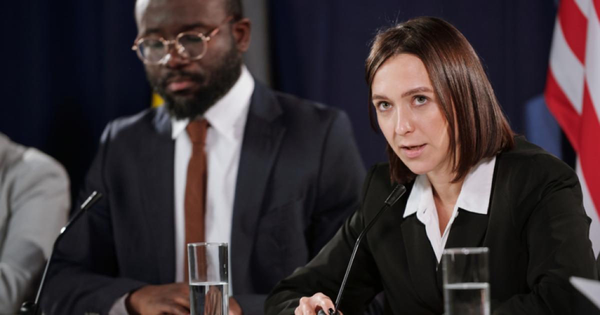 Young confident female politician in formalwear speaking in microphone stock photo (iStock)