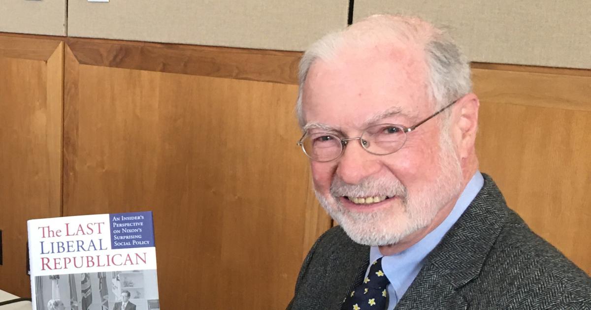 John Roy Price holding a copy of his book on President Nixon