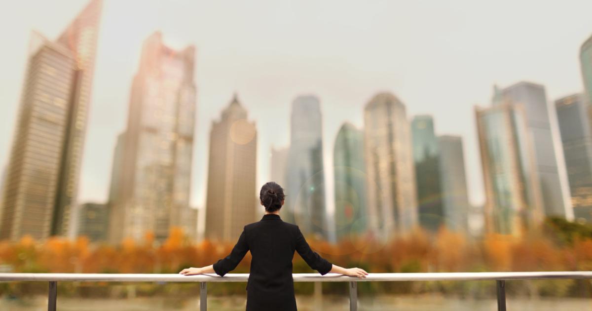 Young woman standing with view of buildings in city downtown