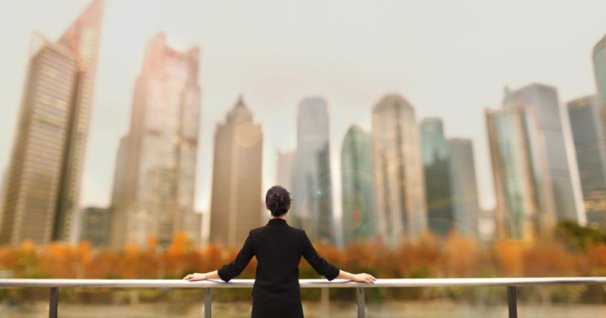 Young woman standing with view of buildings in city downtown