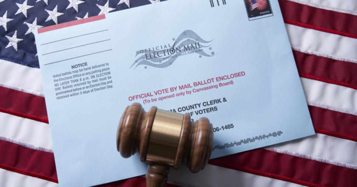 Voting ballot: Absentee voting by mail with ballot envelope on USA flag and gavel stock photo