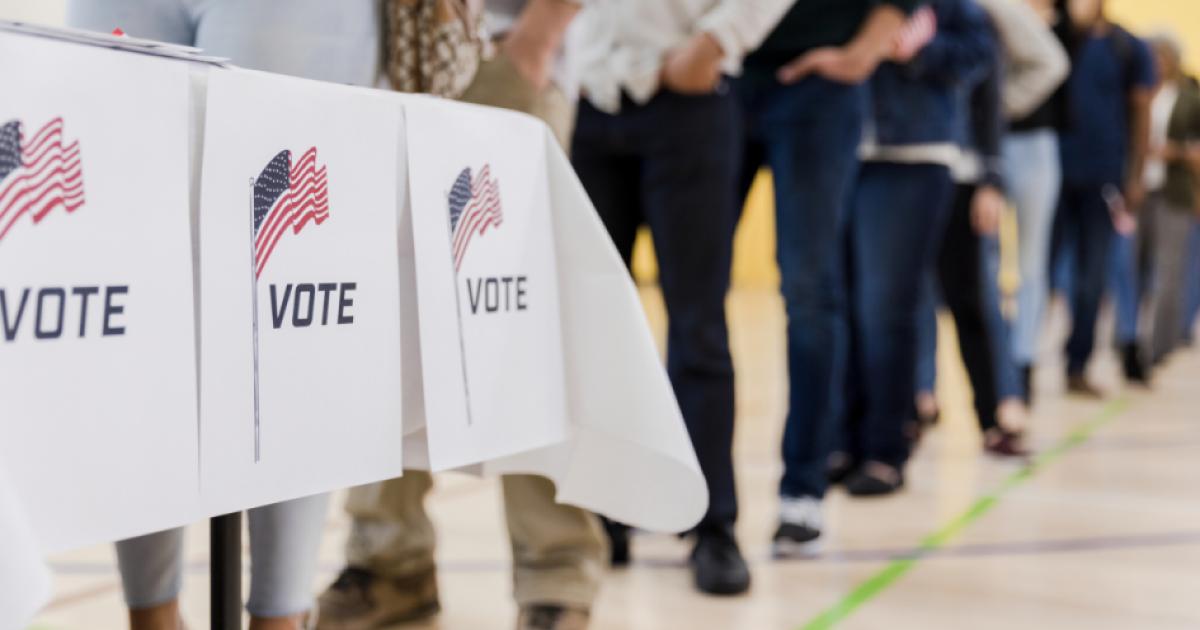 Low angle view of people lined up to vote stock photo