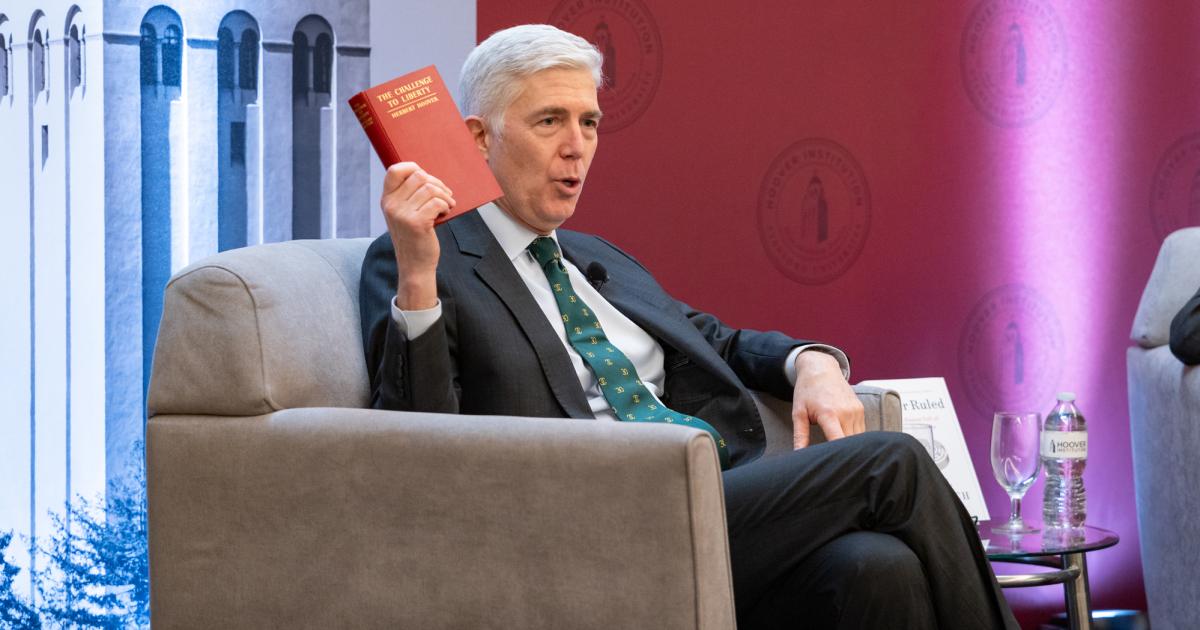 US Supreme Court Justice Neil Gorsuch holds up a copy of Herbert Hoover’s The Challenge to Liberty while speaking at the Hoover Institution’s Winter Board of Overseers meeting on February 24, 2025. 