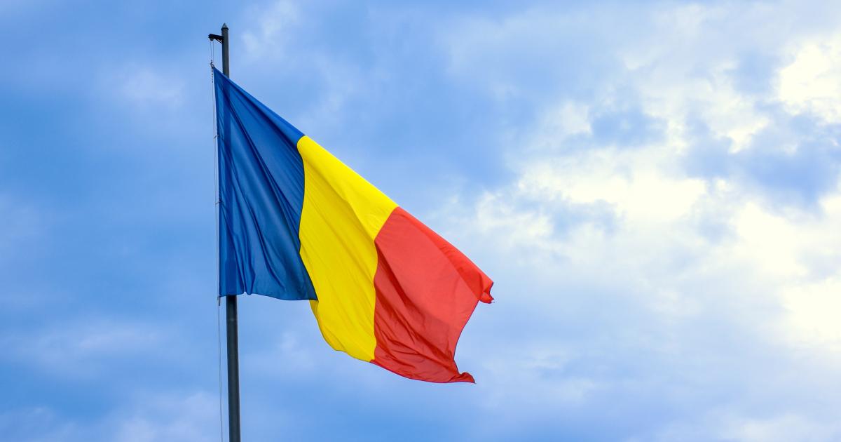 Romanian national flag against romantic sky in Bucharest, Romania - stock photo