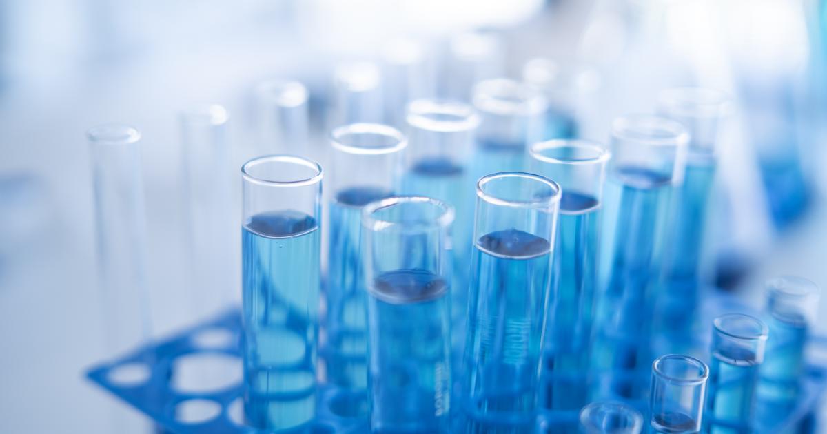 Science laboratory test tubes row with light blue liquid close-up - stock photo