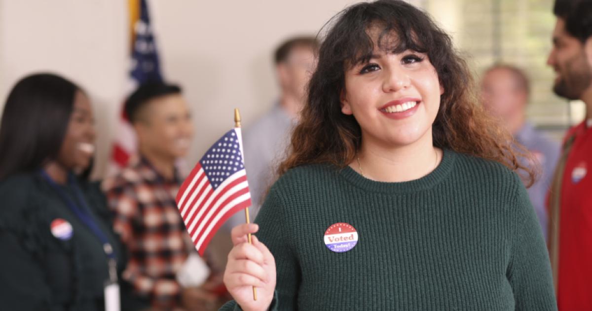 Young adult, Latin descent woman votes in USA election. - stock photo
