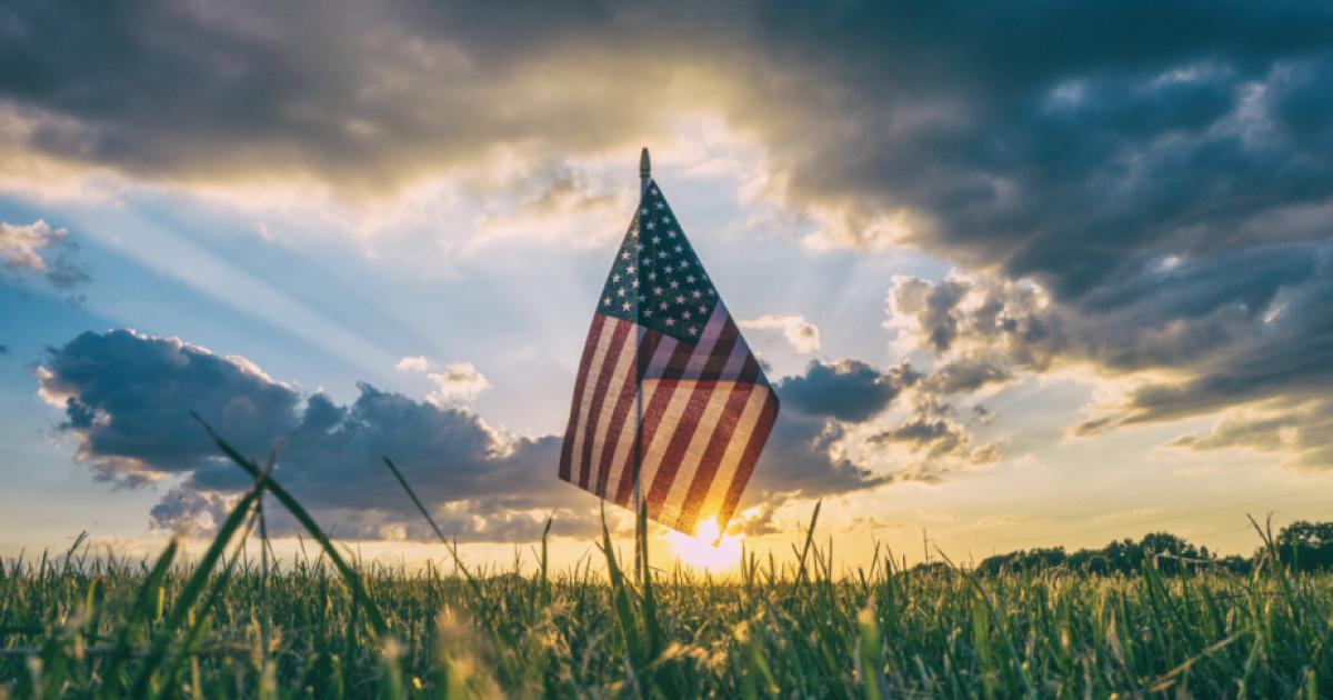 American Flag flying over a field