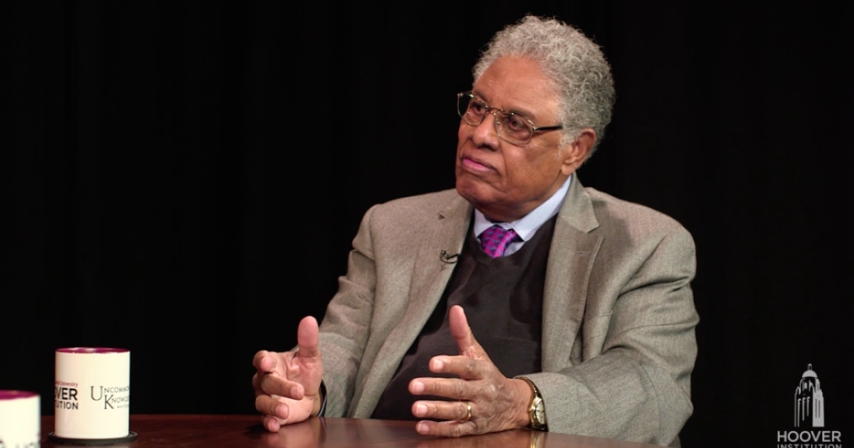 Thomas Sowell in front of a black background with an Uncommon Knowledge mug