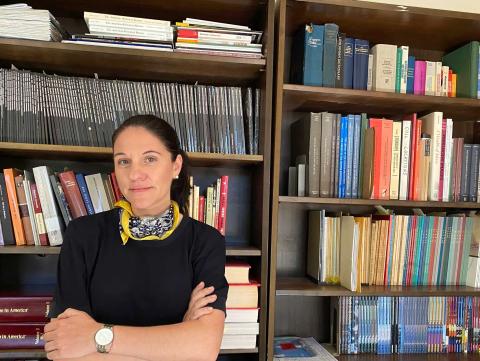 Katharina Friedla standing in front of book case