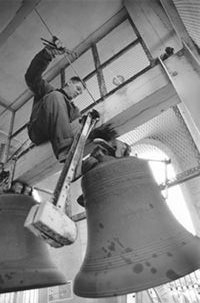 A worker from the Netherlands dismantles one of the largest bells from the Hoover Tower carillon, January 2000. The bells are currently in the Netherlands for refurbishing. Steve Gladfelter/Stanford V